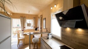 A modern kitchen with wooden cabinets, a stainless steel range hood, and a built-in stove. - Amazing Chalet With hot tub (Sankt Georgen am Kreischberg)