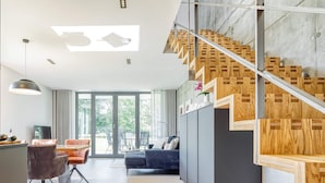 Un interior moderno con una escalera, un comedor y una sala de estar.