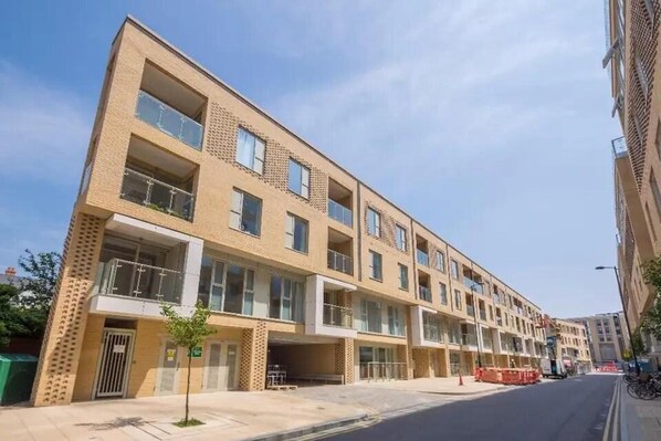 Un immeuble résidentiel à plusieurs étages, doté d’une architecture moderne, de balcons et de grandes fenêtres.