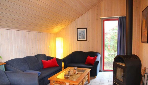 A cozy living room with two sofas, a coffee table, and a fireplace. - Skandinavisches Ferienhaus in Mirow (Mirow)