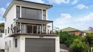 A two-story residential building with a balcony, a garage, and a nameplate reading "SYRRAH".