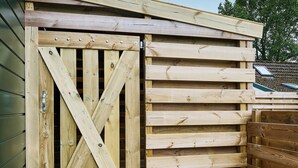 A wooden structure with a cross-braced door and horizontal wooden planks. - Stay at This Beautiful Accommodation in De Kiel (De Kiel)
