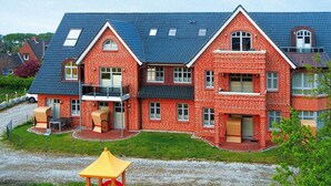 Un grand bâtiment en briques rouges, doté de nombreuses fenêtres et d’un toit plat.