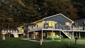 A two-story house with a covered porch, multiple windows, and a staircase leading to a second level.