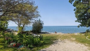 A gravel path leading to a beach with a clear view of the sea.