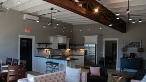 A spacious living area with a large sofa, a dining table with chairs, and a kitchen area with modern appliances. - Historic 2 bedroom steps off downtown square (Mountain Home)