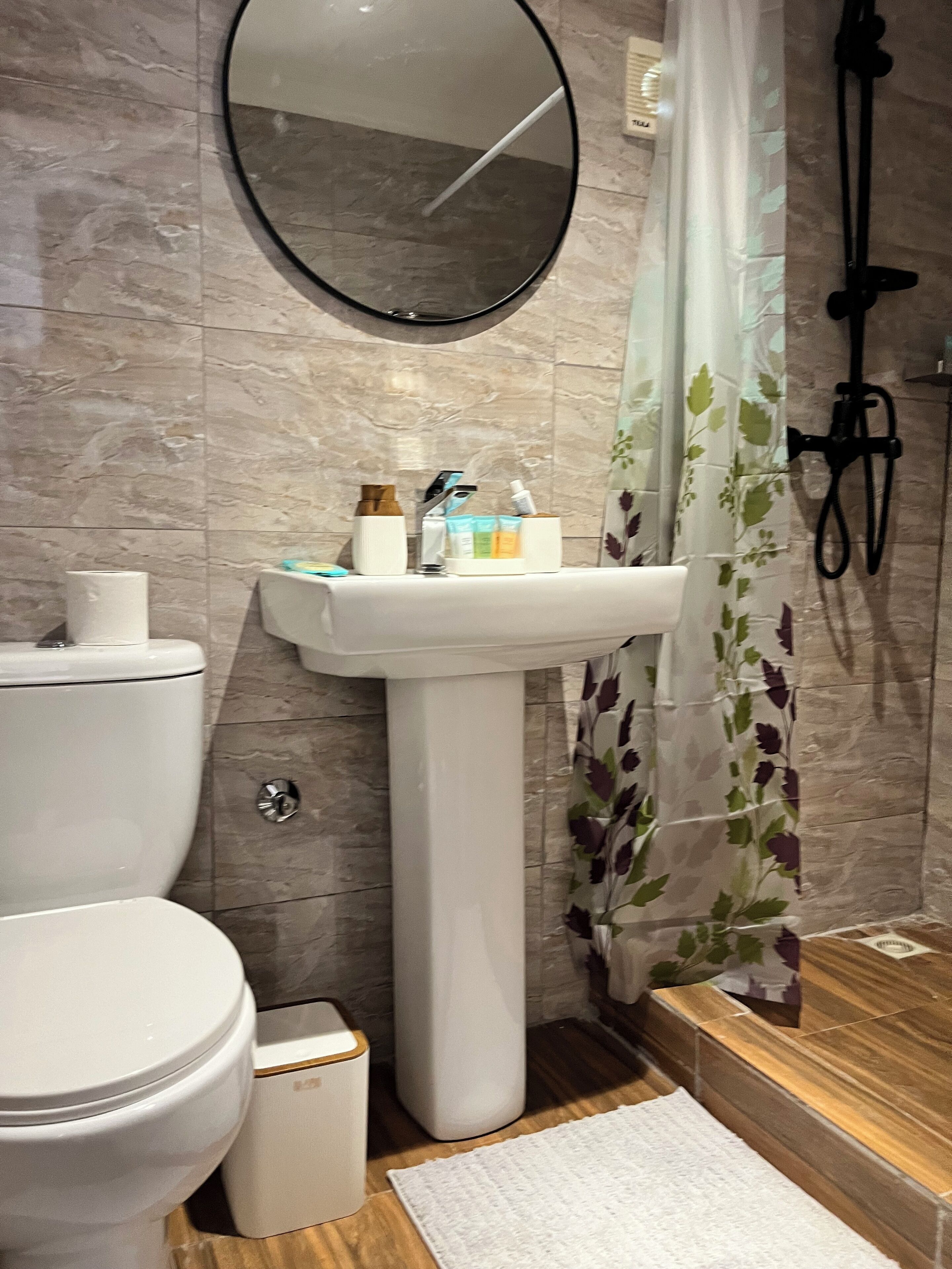 A bathroom with a toilet, sink, and shower.