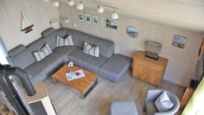 A cozy living room with a grey sectional sofa, a wooden coffee table, and a grey armchair.