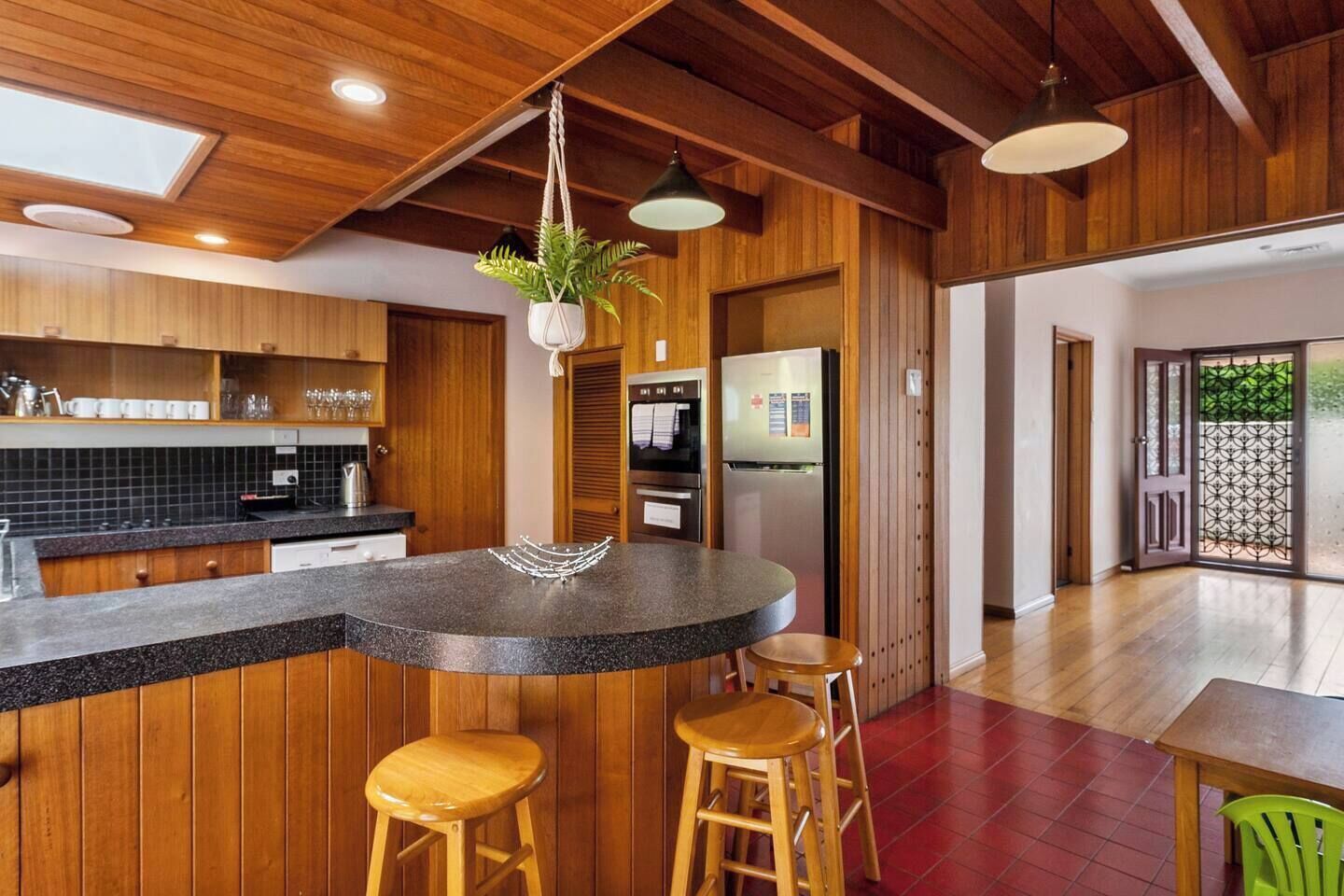 The retro kitchen is cladded in timber and fully-equipped for your holiday catering.