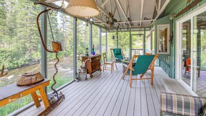A wooden deck with a table, chairs, and a hanging lamp. - 22 Mi to Lost Trail Skiing: Serene Winter Retreat (Sula)