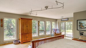 A spacious bedroom with a large bed, wooden wardrobe, and multiple windows offering views of the outdoors. - 22 Mi to Lost Trail Skiing: Serene Winter Retreat (Sula)