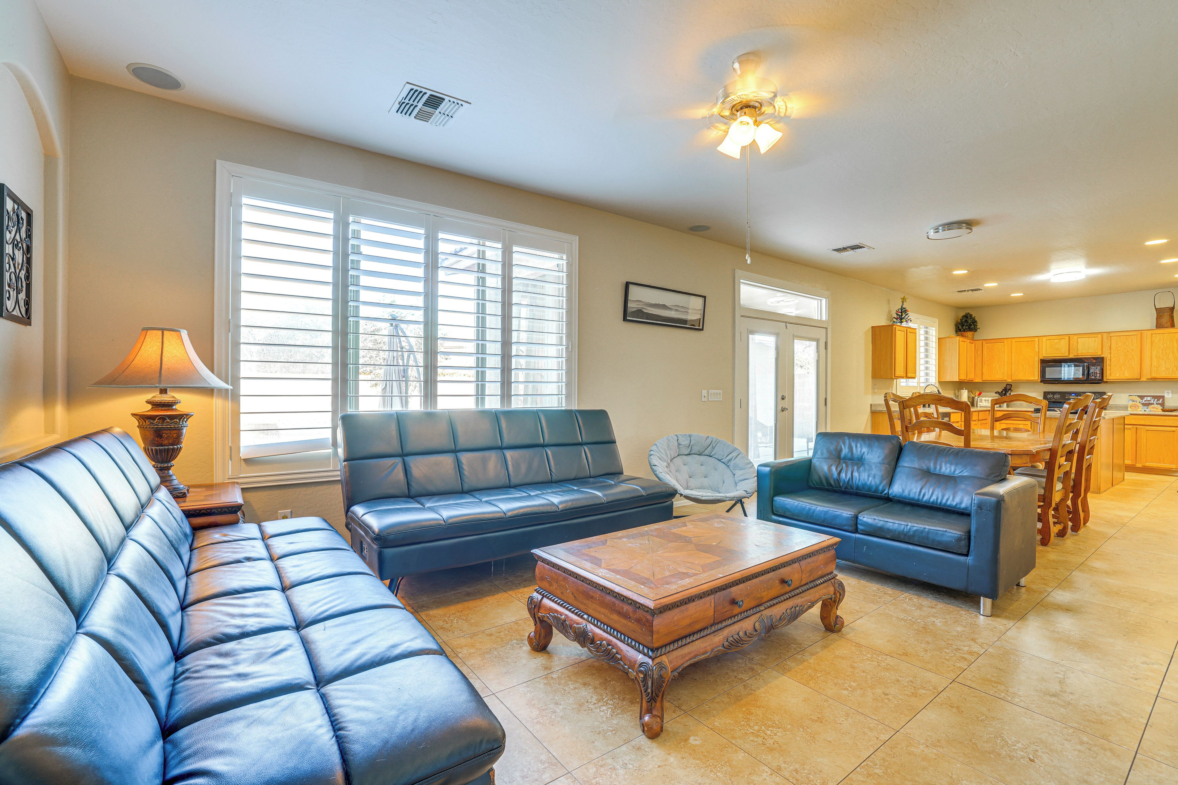 A living room with a sofa, a coffee table, and a dining area with chairs and a table.