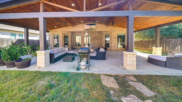Un patio extérieur abrité, doté d’un mur en briques, d’un espace salon et d’un coin barbecue.