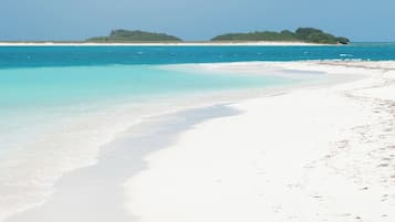 Nära stranden, vit sandstrand, parasoller och strandhanddukar