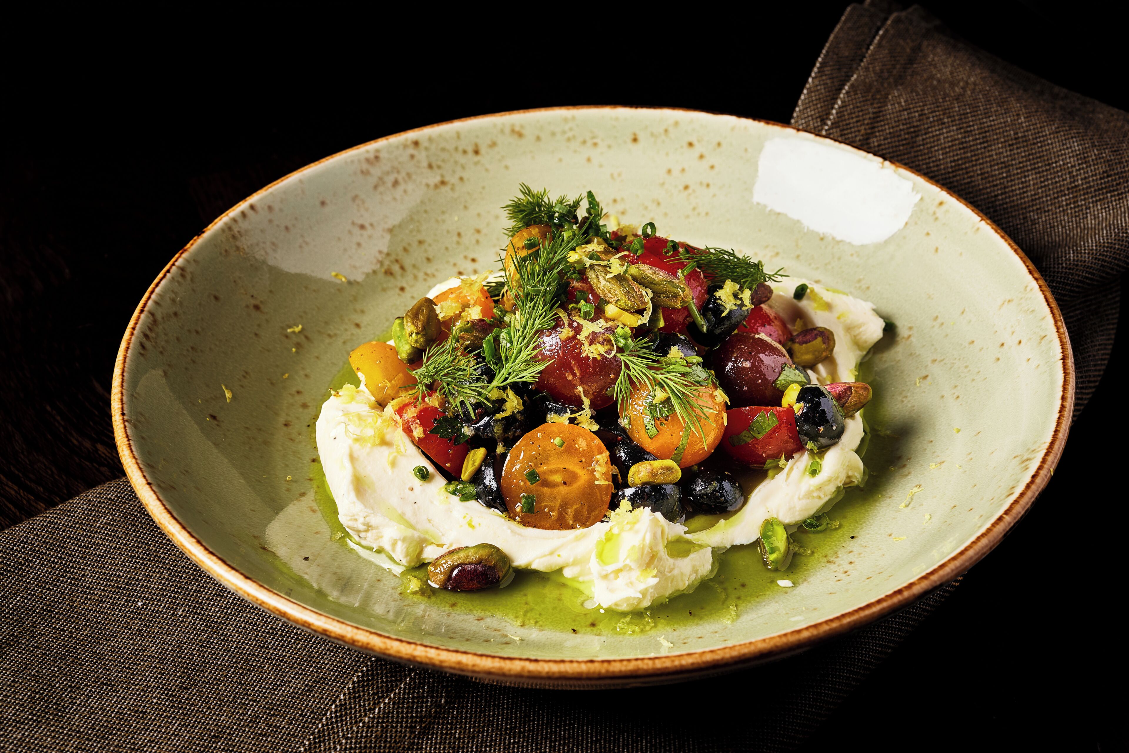 Una ciotola di cibo con diverse verdure ed erbe aromatiche.