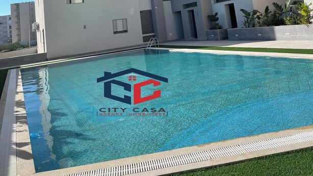 A modern apartment building with a swimming pool in front. - S+2 apartment for rent 15 minutes from the beach on foot  (Mrezga)