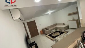 A modern kitchen with a built-in stove, a dining area with a table and chairs, and a small seating area with a sofa. - S+2 apartment for rent 15 minutes from the beach on foot  (Mrezga)