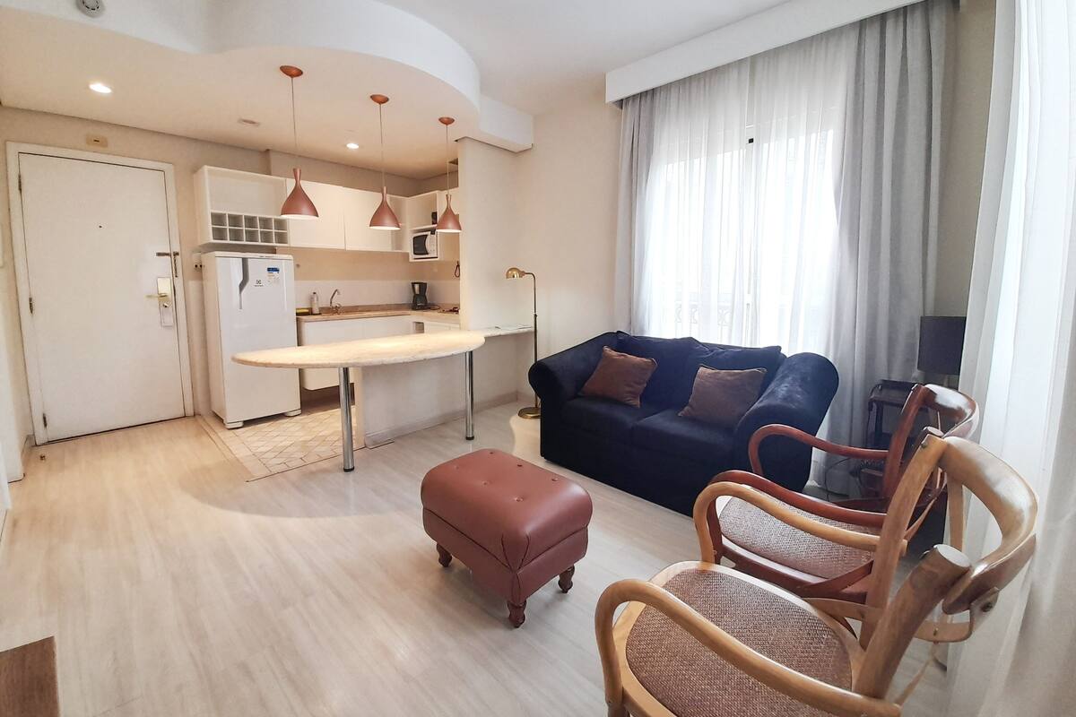 Un espai habitable compacte amb petita cuina, sofà i zona de menjador.