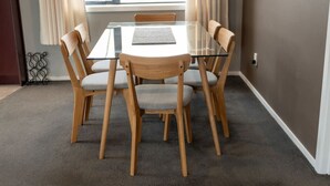 A dining table with six wooden chairs, a glass top, and a placemat. - Restful on Rhoboro - Free Wifi (Twizel)