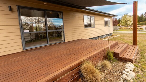 A modern house with a wooden deck, large sliding glass doors, and a covered patio area. - Restful on Rhoboro - Free Wifi (Twizel)