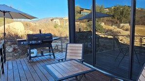 An outdoor deck with a barbecue grill, a table, and chairs. - CASA SEKUI (Valle de Guadalupe)