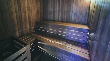 A sauna with wooden benches and a metal bench.