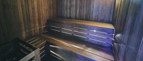A sauna with wooden benches and a metal bench.