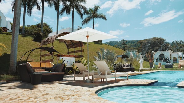 A poolside area with lounge chairs, a pergola, and a view of a hillside. - Dharma Hotel Boutique Spa (San Jerónimo)