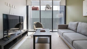 A modern living room with a flat-screen TV, a sofa, a coffee table, and a chair. - Blueground Ava Rio Rhin in Mexico City (Mexico City)