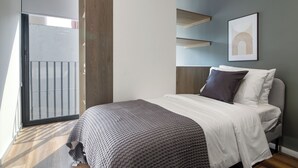 A modern bedroom with a bed, a large window, and a door leading to a balcony. - Blueground Ava Rio Rhin in Mexico City (Mexico City)