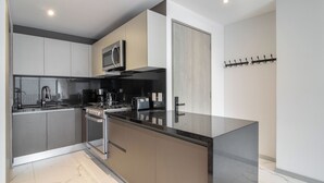 A modern kitchen with a central island, built-in oven, microwave, and stainless steel appliances. - Blueground Ava Rio Rhin in Mexico City (Mexico City)