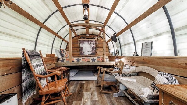 Ein rustikales Interieur mit Holzmöbeln, einem Schaukelstuhl und einer Bank.