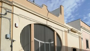 Ein Gebäude mit einem großen Rundfenster, einem Eingangstor und einem Nummernschild.