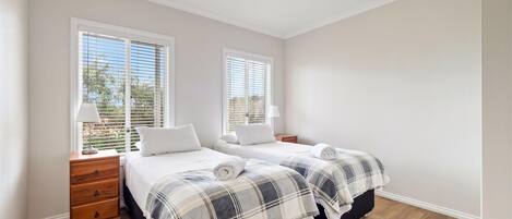 Makuuhuoneessa on kaksi sänkyä, puinen lipasto ja yöpöytä.