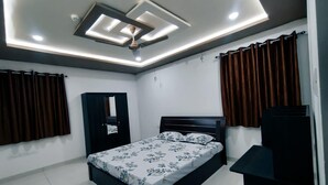 Una camera da letto moderna con un letto, una ventola a soffitto, un armadio e una scrivania.