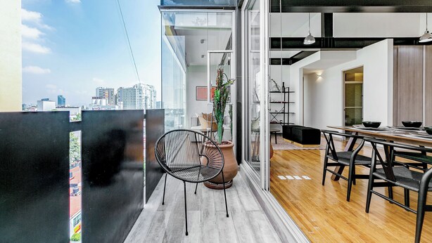 Cozinha moderna com área de refeições, janelas amplas e vista para a cidade.