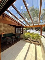Un espacio de estar al aire libre cubierto, con vistas al cielo y a los árboles.