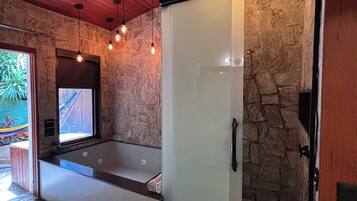 A modern bathroom with a glass shower enclosure, a bathtub, and a large mirror.