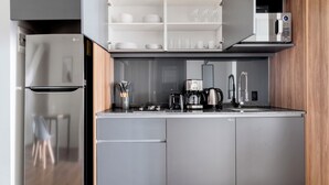 A modern kitchen with a built-in microwave, a coffee maker, and a toaster. - Blueground Josefa by Urbanistas CDMX (Mexico City)