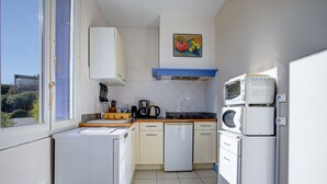 A compact kitchen with white appliances, a coffee maker, and a toaster.