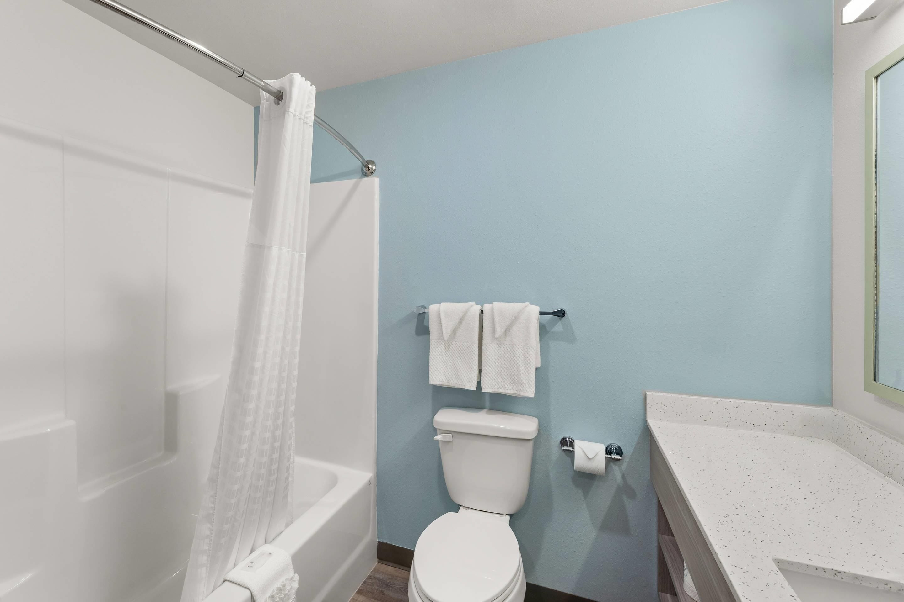 A bathroom with a bathtub, toilet, and a sink.