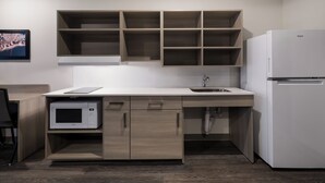 A modern kitchen with a built-in microwave, a sink, and a white refrigerator.