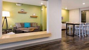 Een moderne woonkamer met een bank, een salontafel en een eethoek met stoelen en een tafel.