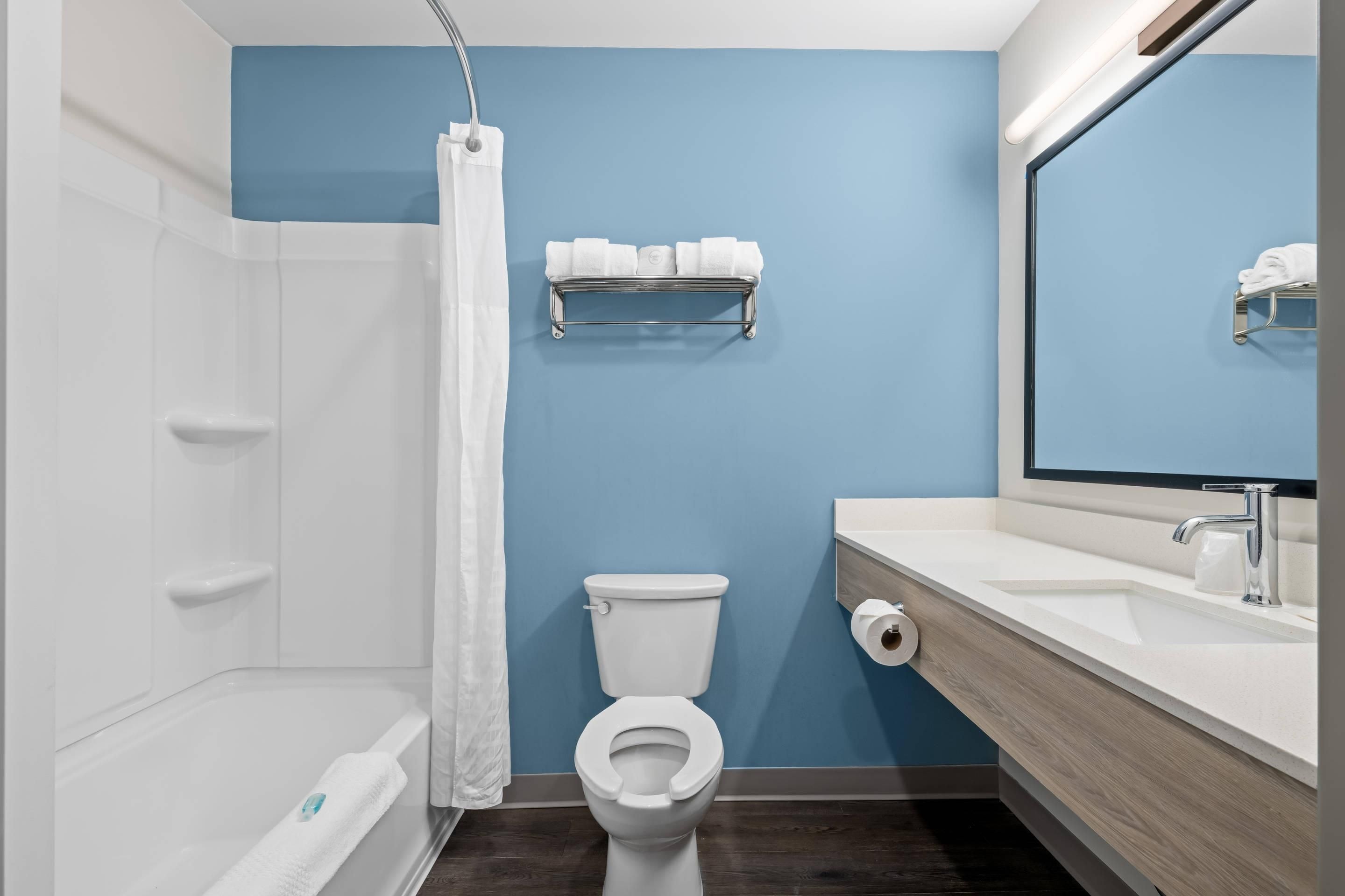 Een moderne badkamer met een badkuip, toilet en wastafel.