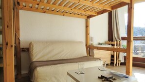 Una habitación acogedora con una cama, una mesa con vasos y vistas al exterior.