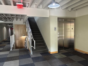 A hotel lobby with a staircase, an elevator, and an exit sign. - Private Charming Midtown 1-bedroom apartment in amazing Detroit with WiFi, AC (Detroit)