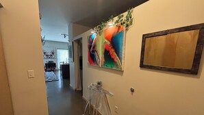 A hallway with a clear view of a dining area, a kitchen, and a living space.