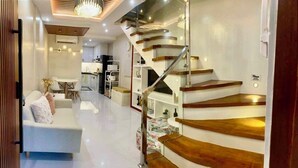 A modern interior with a staircase, a dining area, and a living room. - Charming 2-BR House in San Jose Del Monte w/ WiFi, 3 split-type ACs, & Netflix (San Jose Del Monte)