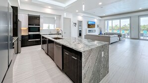 A modern kitchen with granite countertops, dark cabinetry, and a central island. - Really Fun House with tons of room, huge pool plenty to do and a terrific view  (Kissimmee)