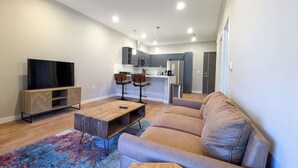 Una sala de estar moderna con un sofá, una mesa de centro y un televisor.